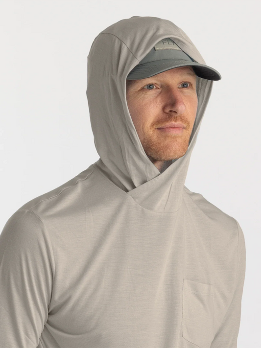 Man wearing a tan hoodie shirt with a hat and hood up.