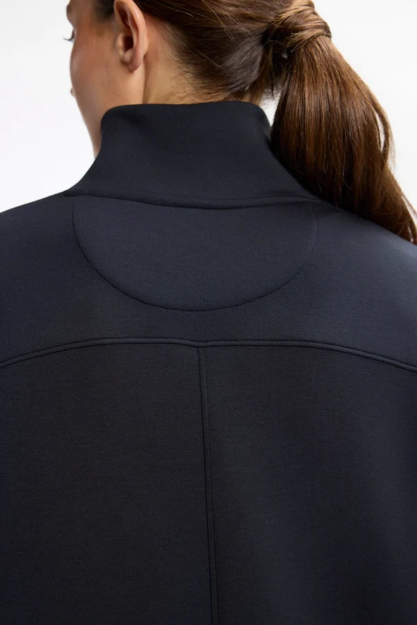 Close up of the back of a women neck with a mock neck dress