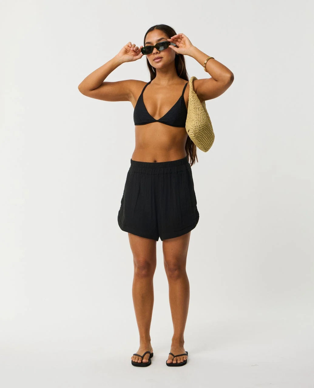 Rip Curl Premium Surf Short Woman wearing a black bikini and shorts with sunglasses on a white background