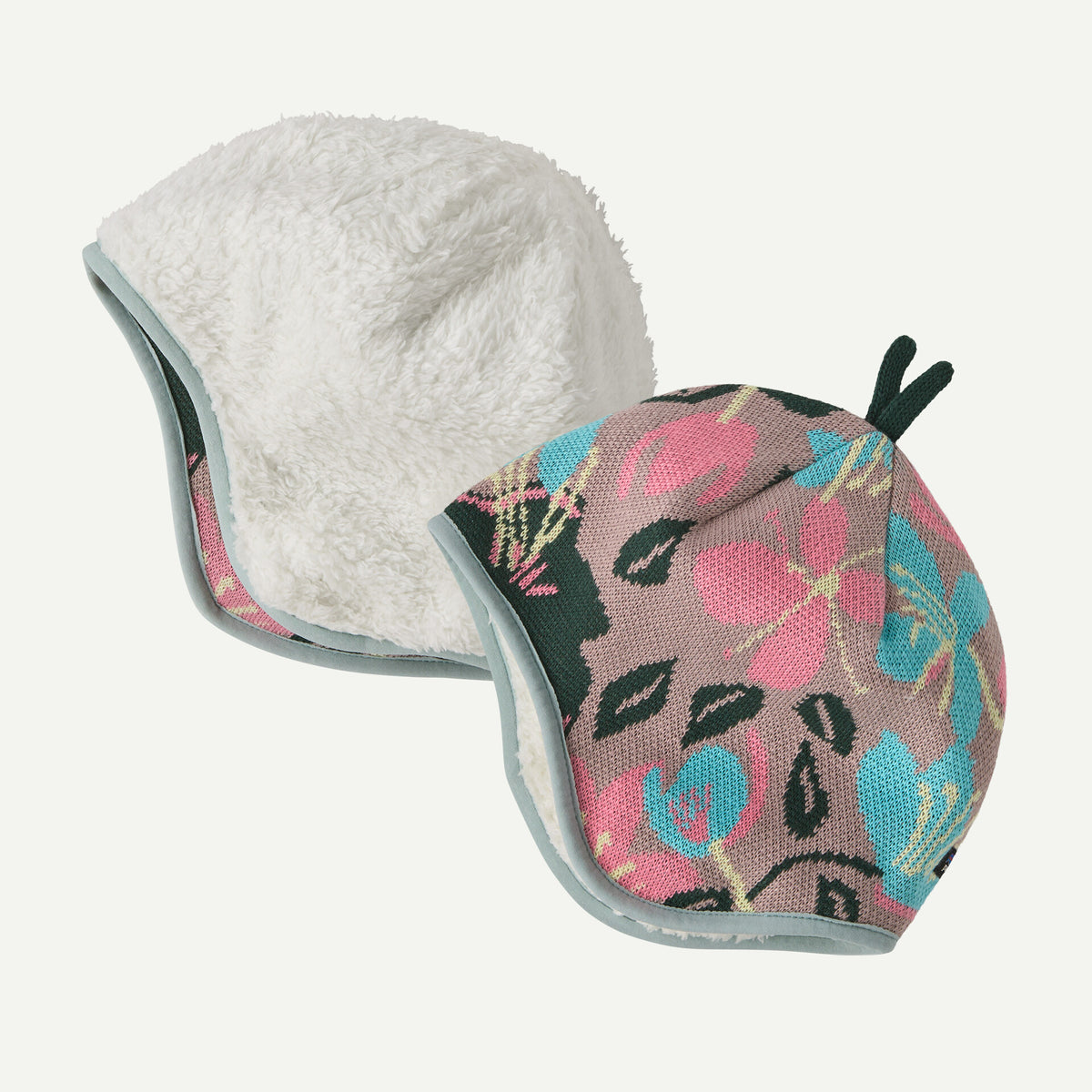 A youth reversible beanie with white on one side and mauve floral print on the other