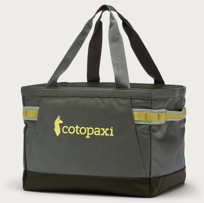 A green Cotopaxi Allpa Gear Hauler Tote bag with orange straps and handles, and the brand's logo on the side.