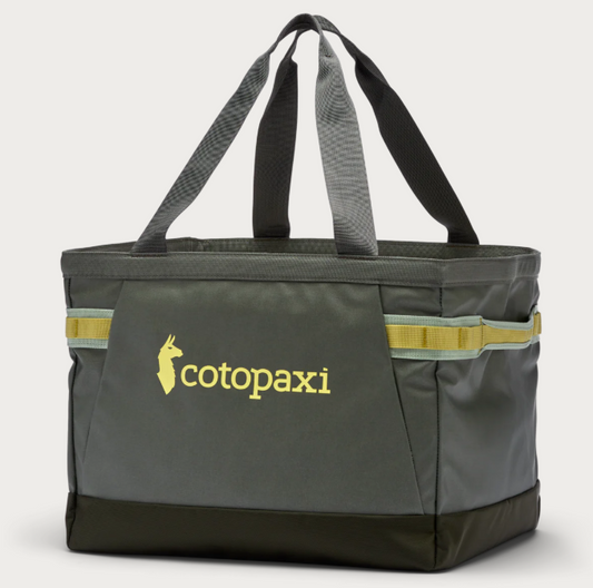 A green Cotopaxi Allpa Gear Hauler Tote bag with orange straps and handles, and the brand's logo on the side.