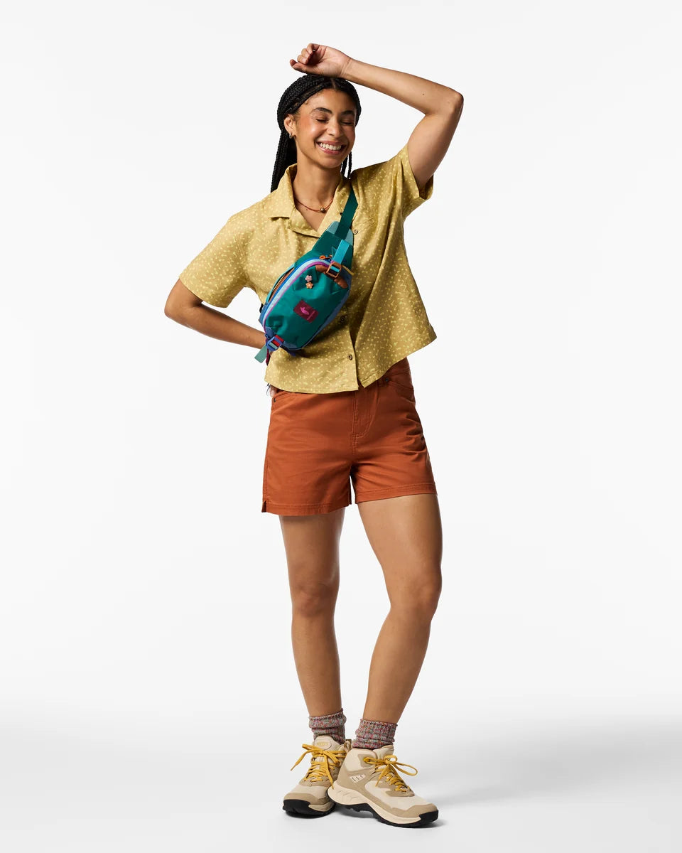 A woman standing with an allpa fanny pack cross body 