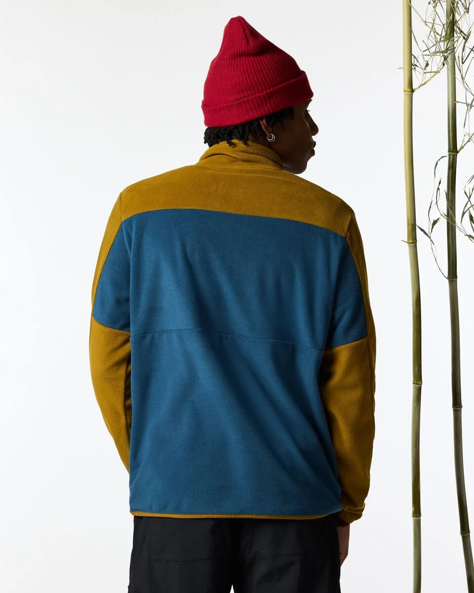 A man wears a 2 coloured blocked sweater form Cotopaxi 