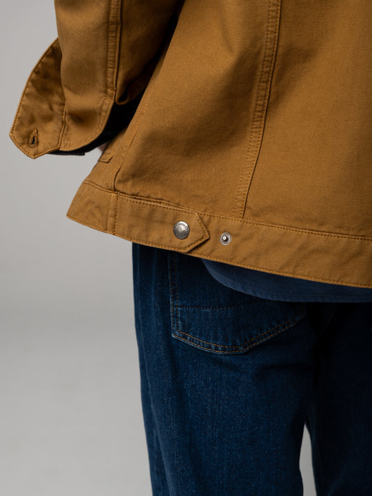 Brown jacket and blue jeans on a gray background