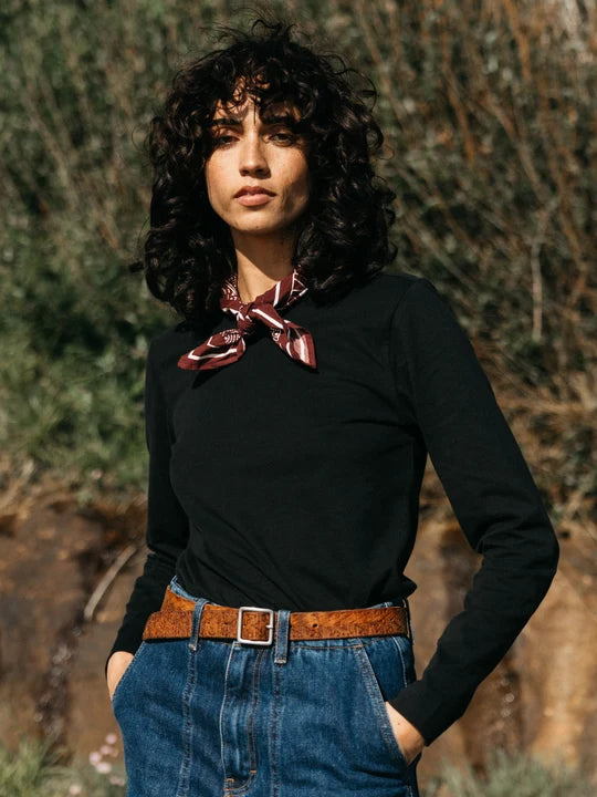 A woman stands outside wearing a scarf and black long sleeve available  at CHANGE Lifestyle & Apparel