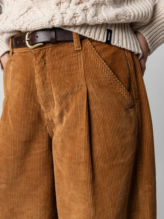 A person wearing a brown cord pant with belt