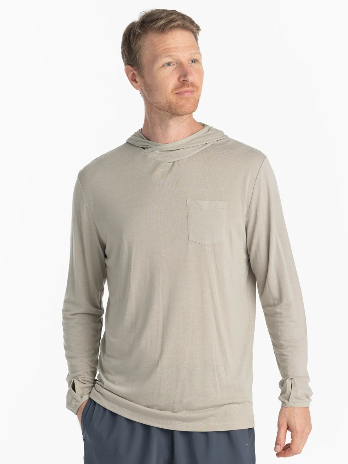 Man standing wearing a tan colour UPF shirt with hood