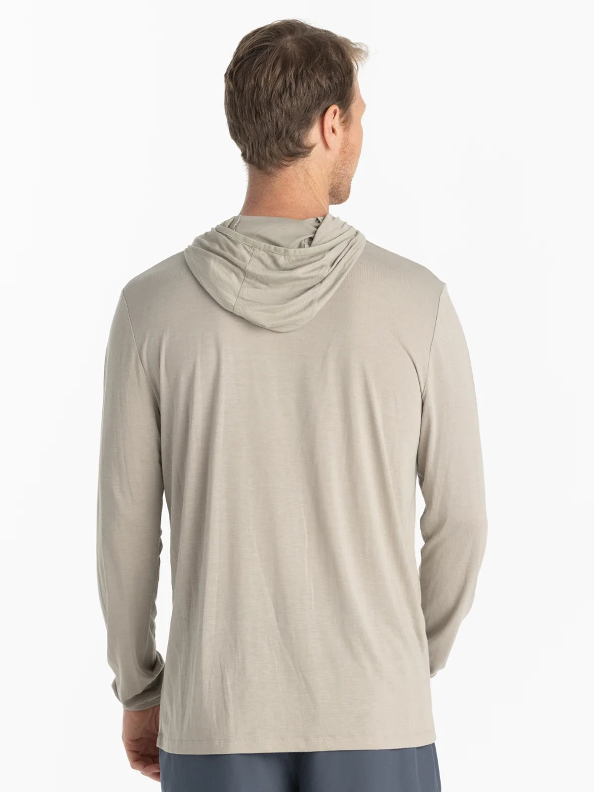 The back view of a man wearing a tan coloured UPF hoodie 