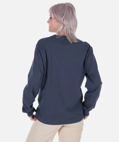 A woman with light purple hair is shown from the back wearing a dark navy blue long-sleeve top and beige pants against a plain white background.