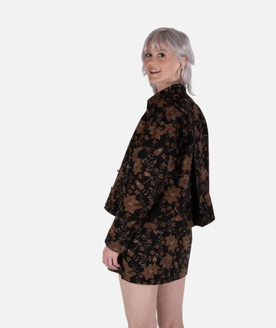 Jetty Supply Piper Jacket Woman wearing a black floral dress against a white background