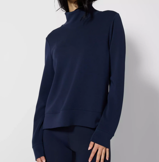 Navy blue long-sleeve top worn by a person on a light gray background