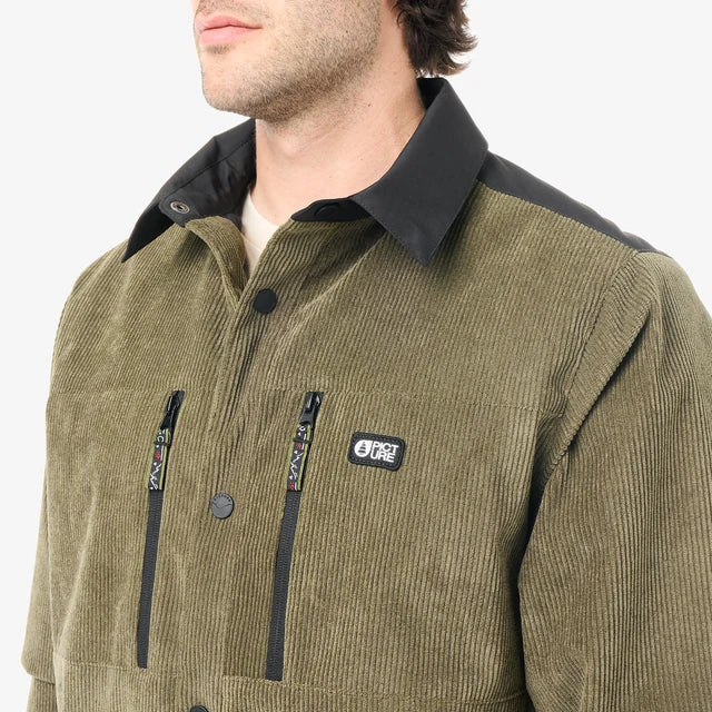A close up of a  man wearing a green cord shirt that has 2 zipper pockets