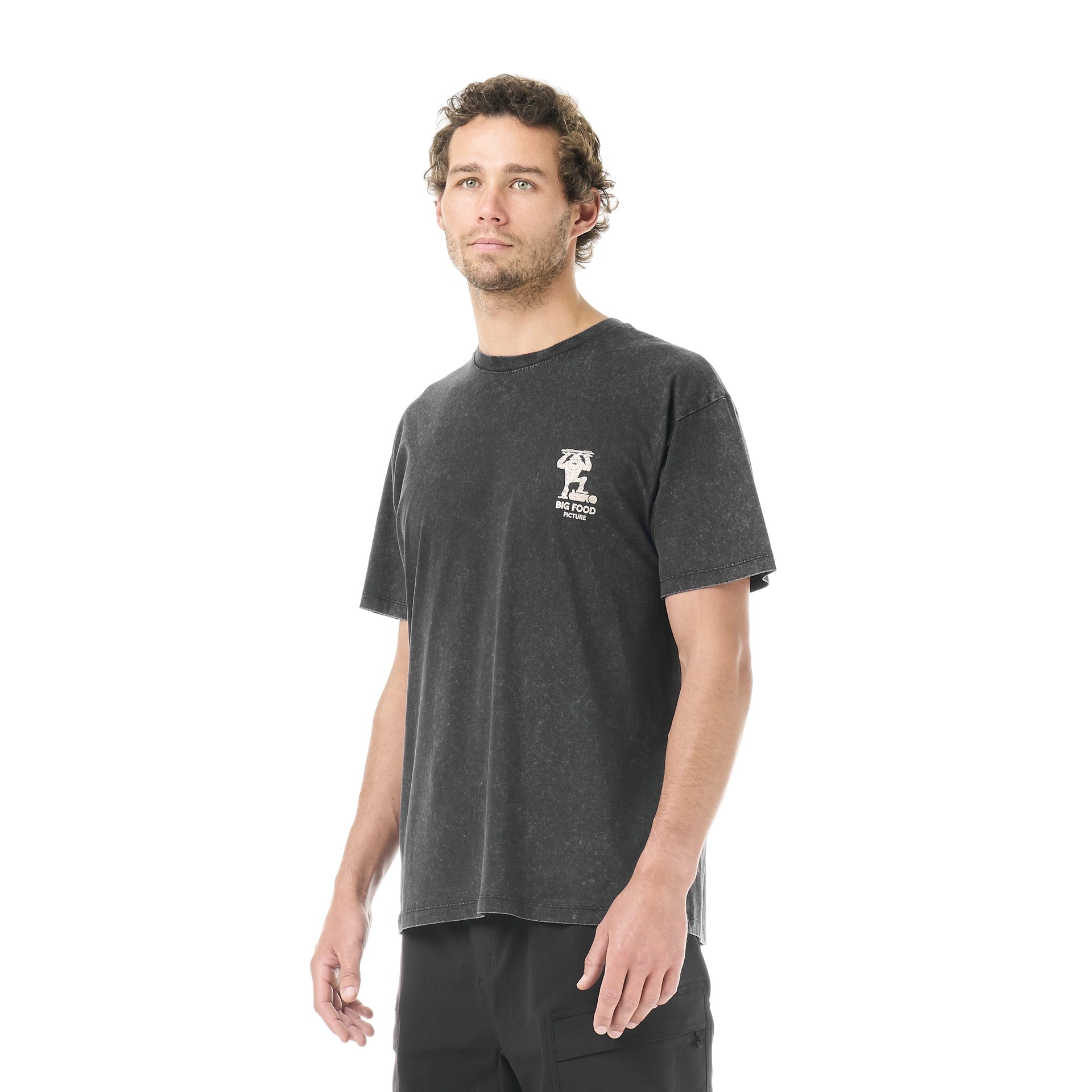 Picture Organic Big Foot Tee A man wearing a dark charcoal gray t-shirt with a small white graphic on the left chest, standing against a solid white background.
