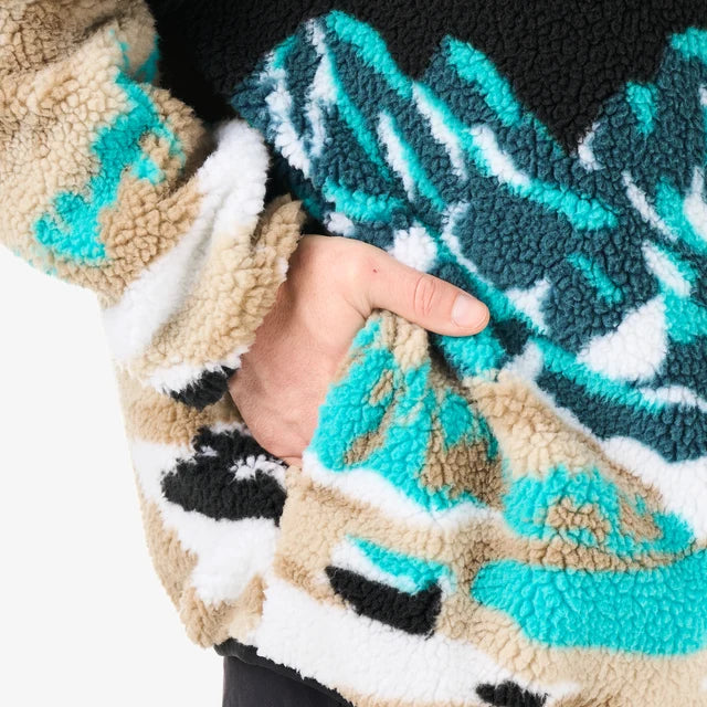 A person has their hand in the pocket of a multi coloured fleece