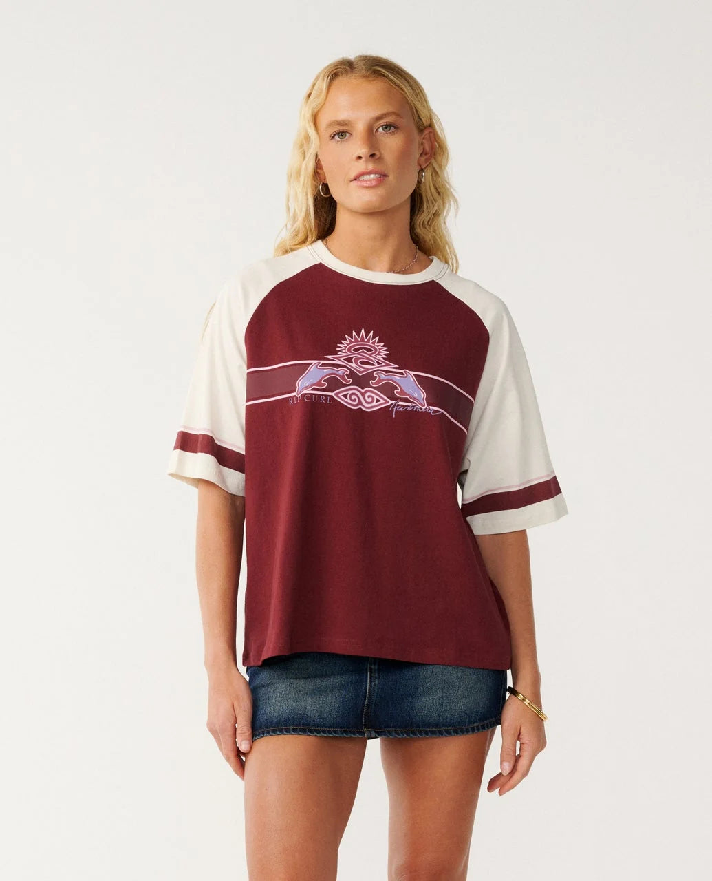 Rip Curl Dolphin T Shirt Woman wearing a maroon and white baseball-style shirt with a graphic design on a plain background