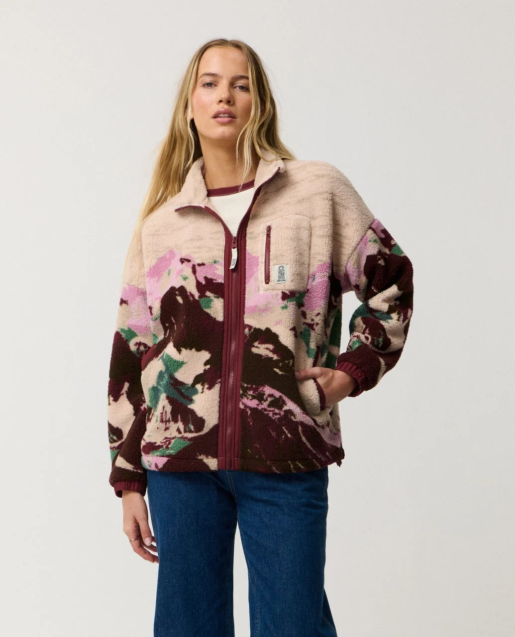 Woman wearing a colorful jacket with a neutral background