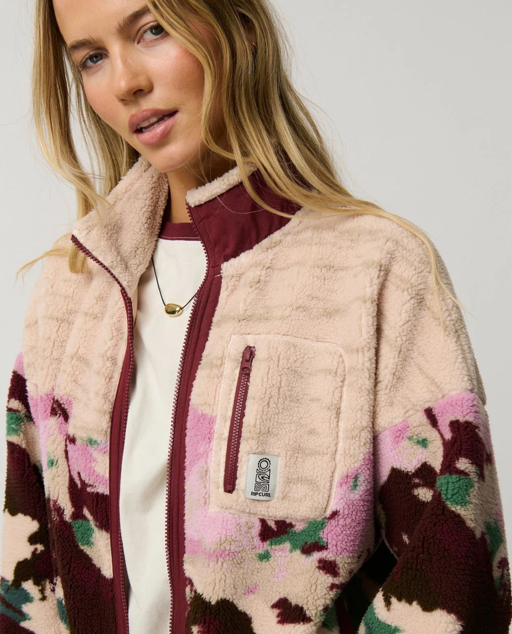 Woman wearing a patterned jacket with a neutral background