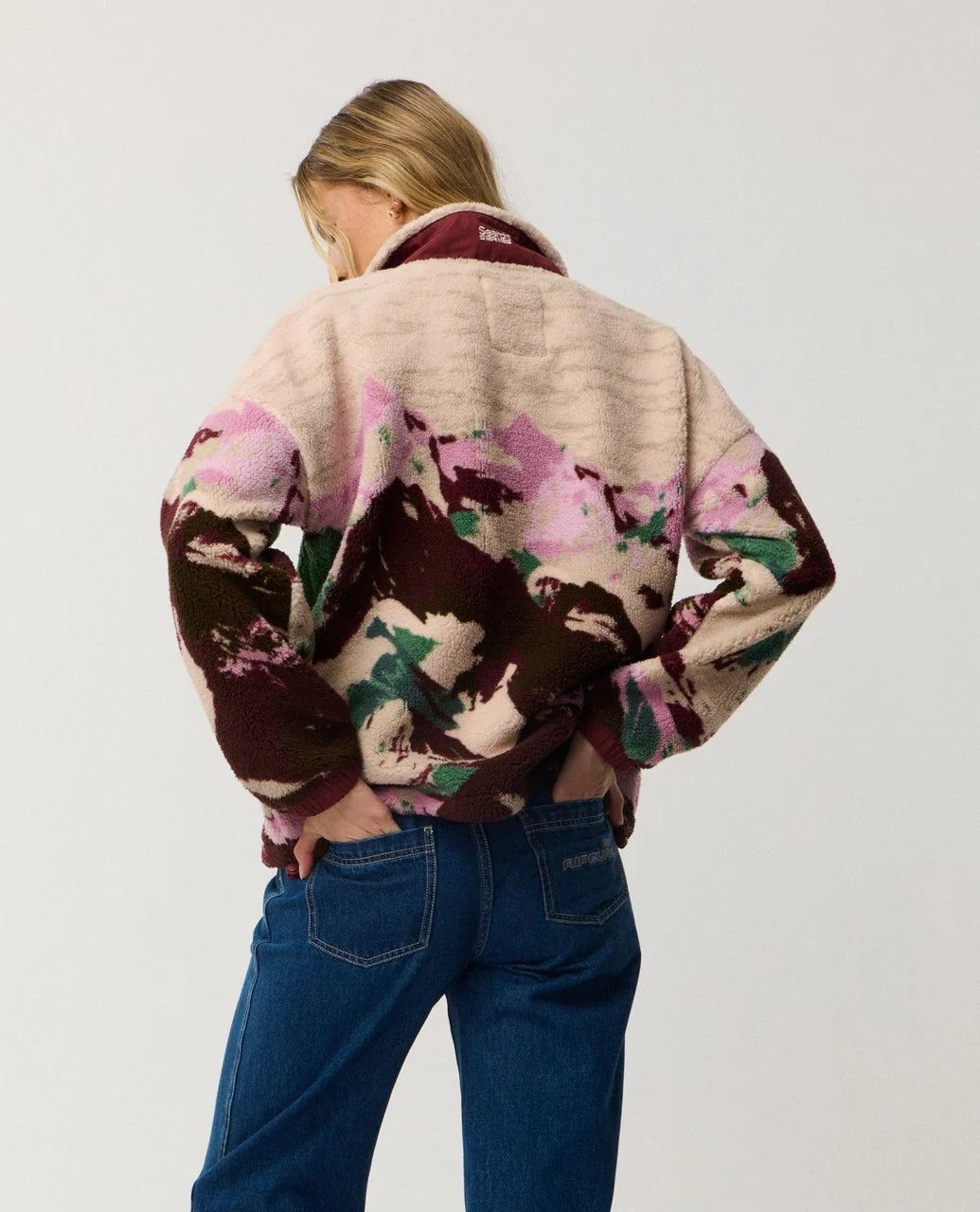 Person wearing a patterned jacket with a neutral background