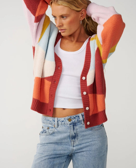 Rip Curl Surf Revival Jacquard Cardigan a woman holds her hair back with a bright and colourful cardigan unbuttoned.
