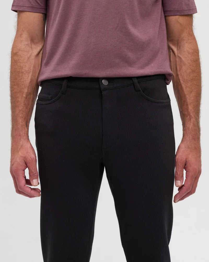 A man wearing a purple top and black Clark pants with 2 front pockets