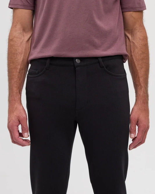 A man wearing a purple top and black Clark pants with 2 front pockets