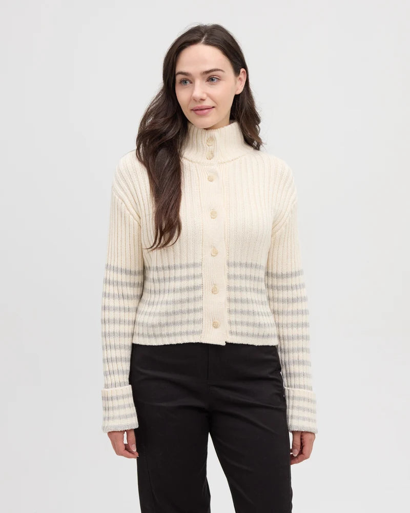 a woman wearing a cream and grey striped monarch cardigan from tentree, and black pants