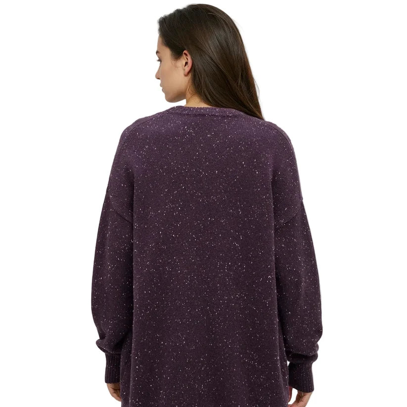 The back view of a woman wearing a long fleck cardigan in purple