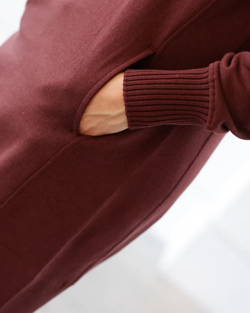 A woman has her hands in a pocket of a dress