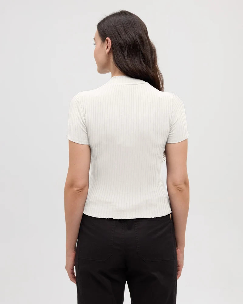 Tentree Whitney Mockneck A woman shown from the back wearing a short-sleeve ribbed knit top in off-white and black pants, photographed against a plain light gray studio background.