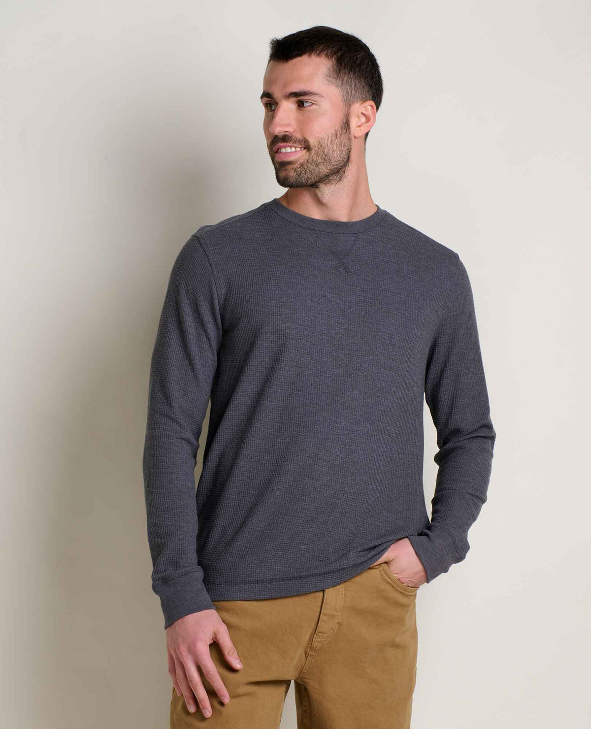 Man wears a soot coloured waffle long sleeve with tan pants