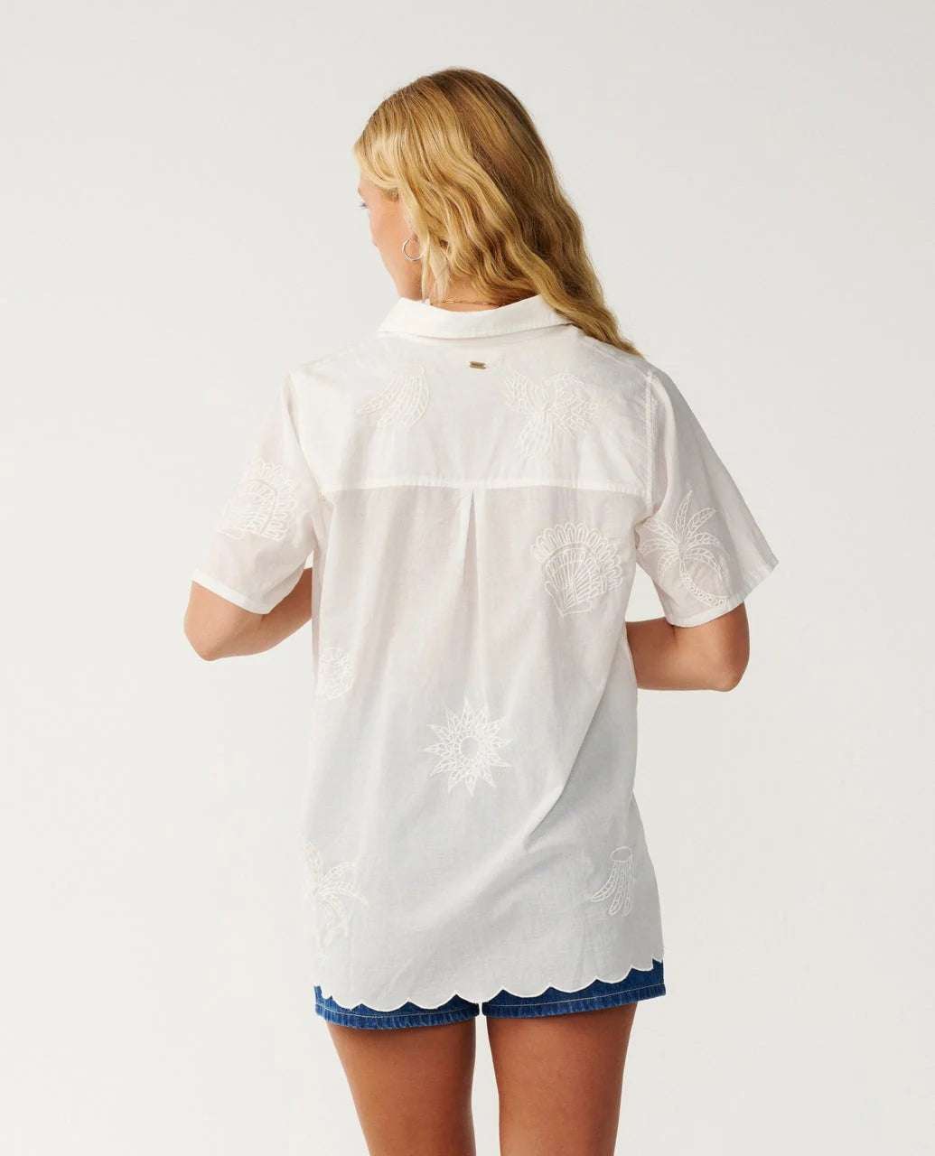 Rip Curl Bossa Nova Emb Short Sleeve Shirt Woman wearing a white embroidered shirt with scalloped hem on a plain background