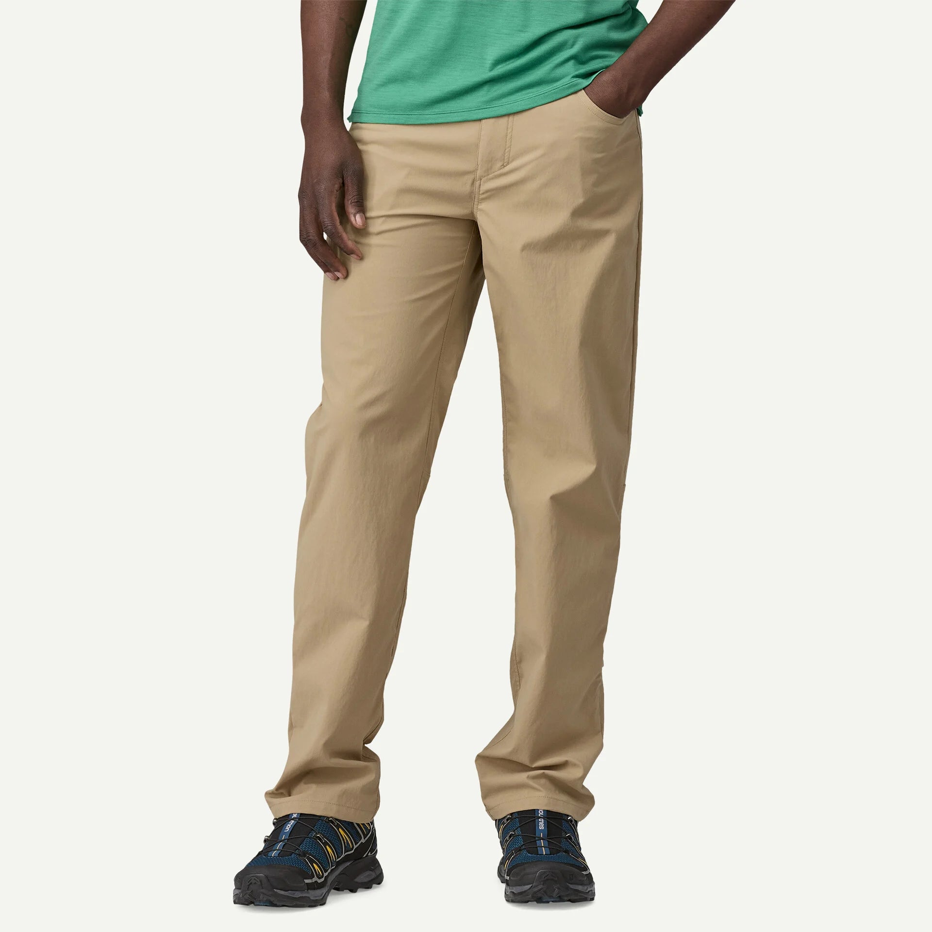 Beige pants worn by a person on a white background