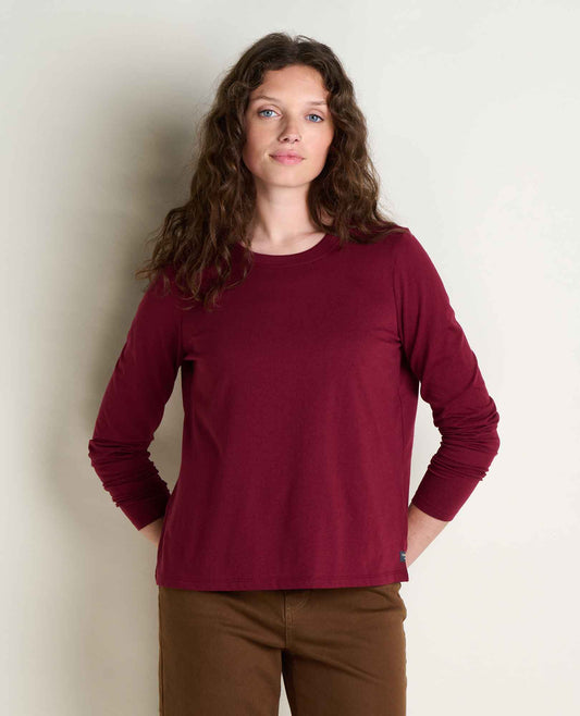 toad and co re form long sleeve crew woman wearing burgundy long sleeve shirt wiht tan pants
