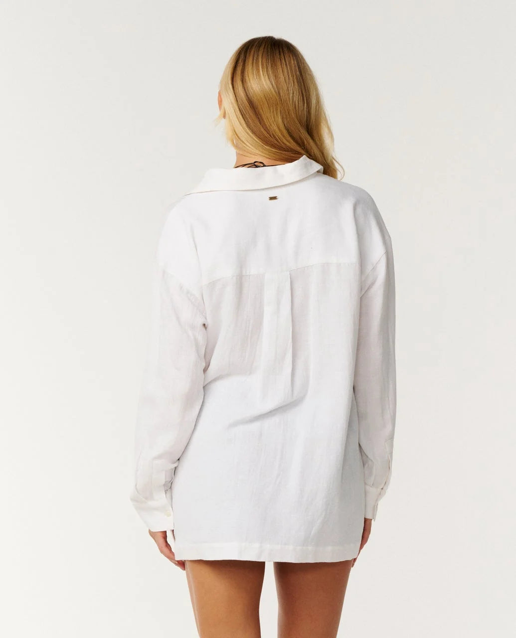 rip curl vibe Person wearing a white denim shirt on a plain background