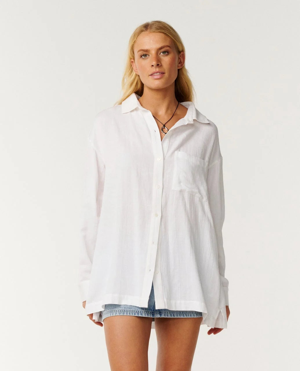 Rip CUrl Vibe Woman wearing a white shirt and denim shorts on a plain background